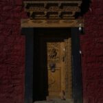 Monk Village - a yellow door in a red brick building