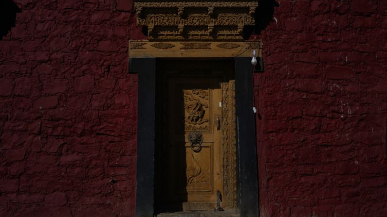 Monk Village - a yellow door in a red brick building
