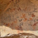 Cave Paintings - a large rock with some writing on it