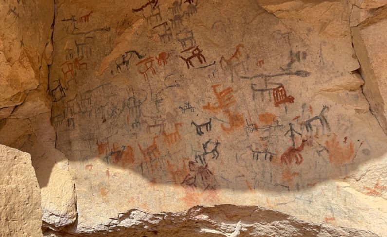 Cave Paintings - a large rock with some writing on it