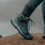 Hiking Boots - person in gray nike running shoes