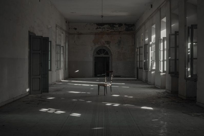 Abandoned Building - person in white shirt sitting on chair