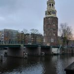 Historic Architecture - a large clock tower towering over a river